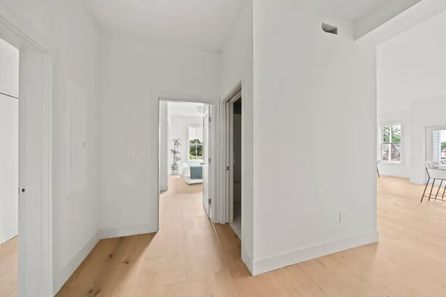 a view of a hallway with wooden floor and a room