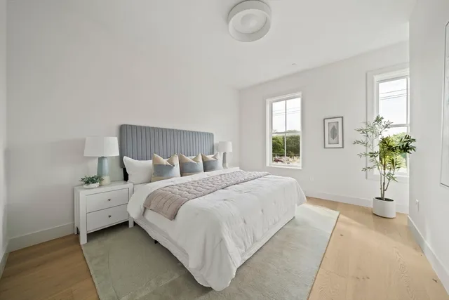 a bedroom with a large bed and a potted plant