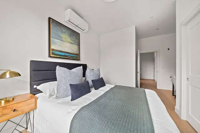 a bedroom with a bed and wooden floor