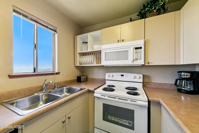 a kitchen with white cabinets sink and white appliances