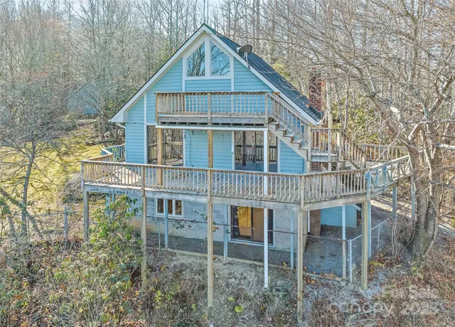 a house view with a wooden fence and a trees
