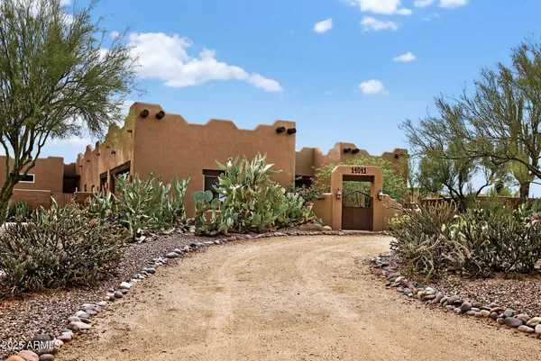 a front view of a house with a yard and fountain