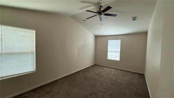 an empty room with a window and a fan