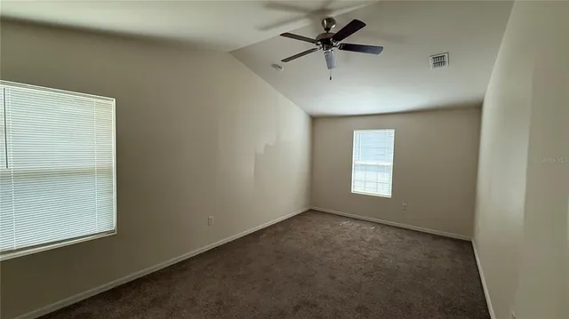 an empty room with a window and a fan
