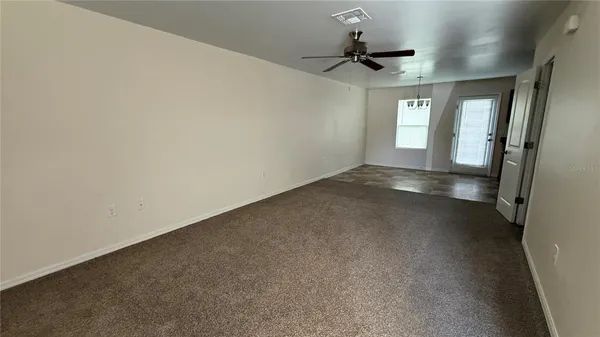 a view of a room with a ceiling fan and window