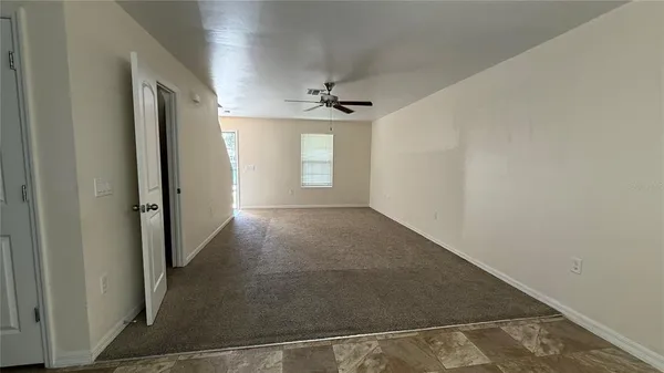 an empty room with windows and cabinet
