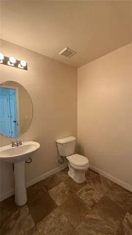 a bathroom with a sink a toilet and mirror