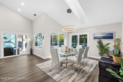 a dining room with wooden floor and a floor to ceiling window