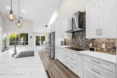 a kitchen with stainless steel appliances kitchen island granite countertop a sink and wooden cabinets