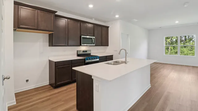 a kitchen with a sink cabinets and wooden floor