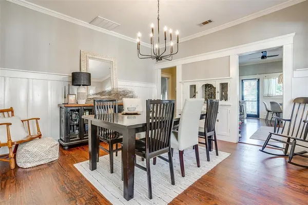 a view of a dining room with furniture a chandelier and wooden floor