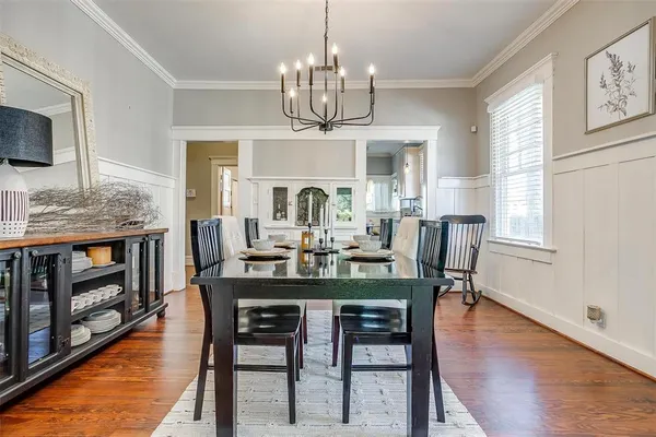 a view of a dining room with furniture a chandelier and wooden floor