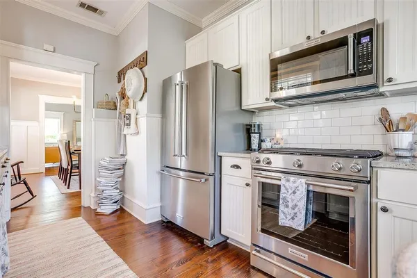 a kitchen with granite countertop a refrigerator stove and microwave