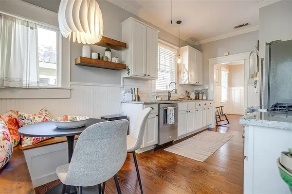 a kitchen with stainless steel appliances granite countertop a stove a sink dishwasher and cabinets with wooden floor