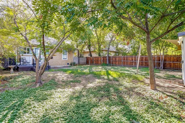 a view of a yard with a house and a large tree