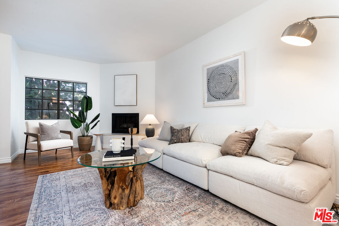 a living room with furniture a fireplace and a potted plant