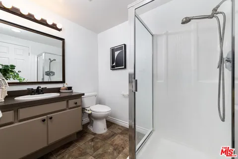 a bathroom with a toilet a sink a vanity and mirror