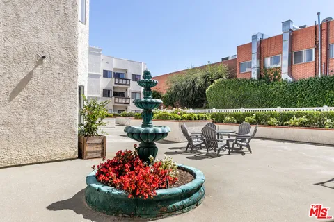 a view of a patio with a table and chairs and potted plants