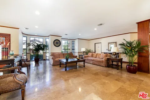 a living room with furniture potted plant and a large window