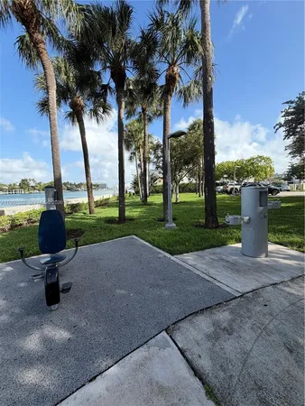 a row of palm trees and a fire pit in the patio next to a yard