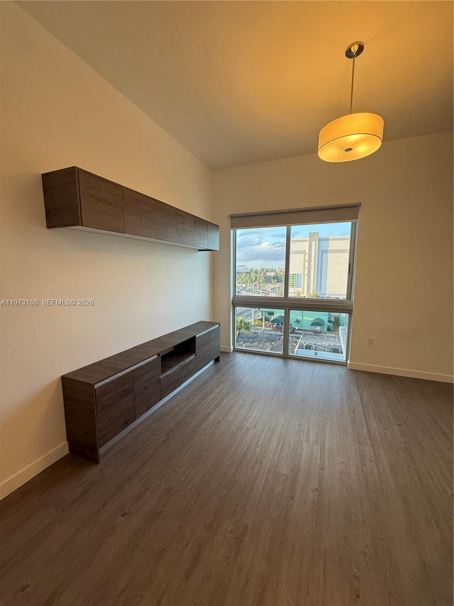 61 Northwest 37th Avenue, Unit 414 Miami, FL 33125 - Photo 5 of 18 an empty room with wooden floor and windows