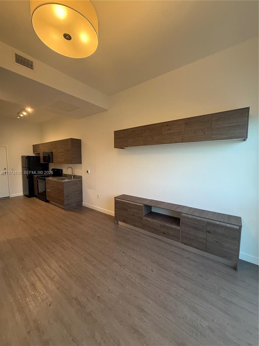 61 Northwest 37th Avenue, Unit 414 Miami, FL 33125 - Photo 6 of 18 a view of kitchen and wooden floor