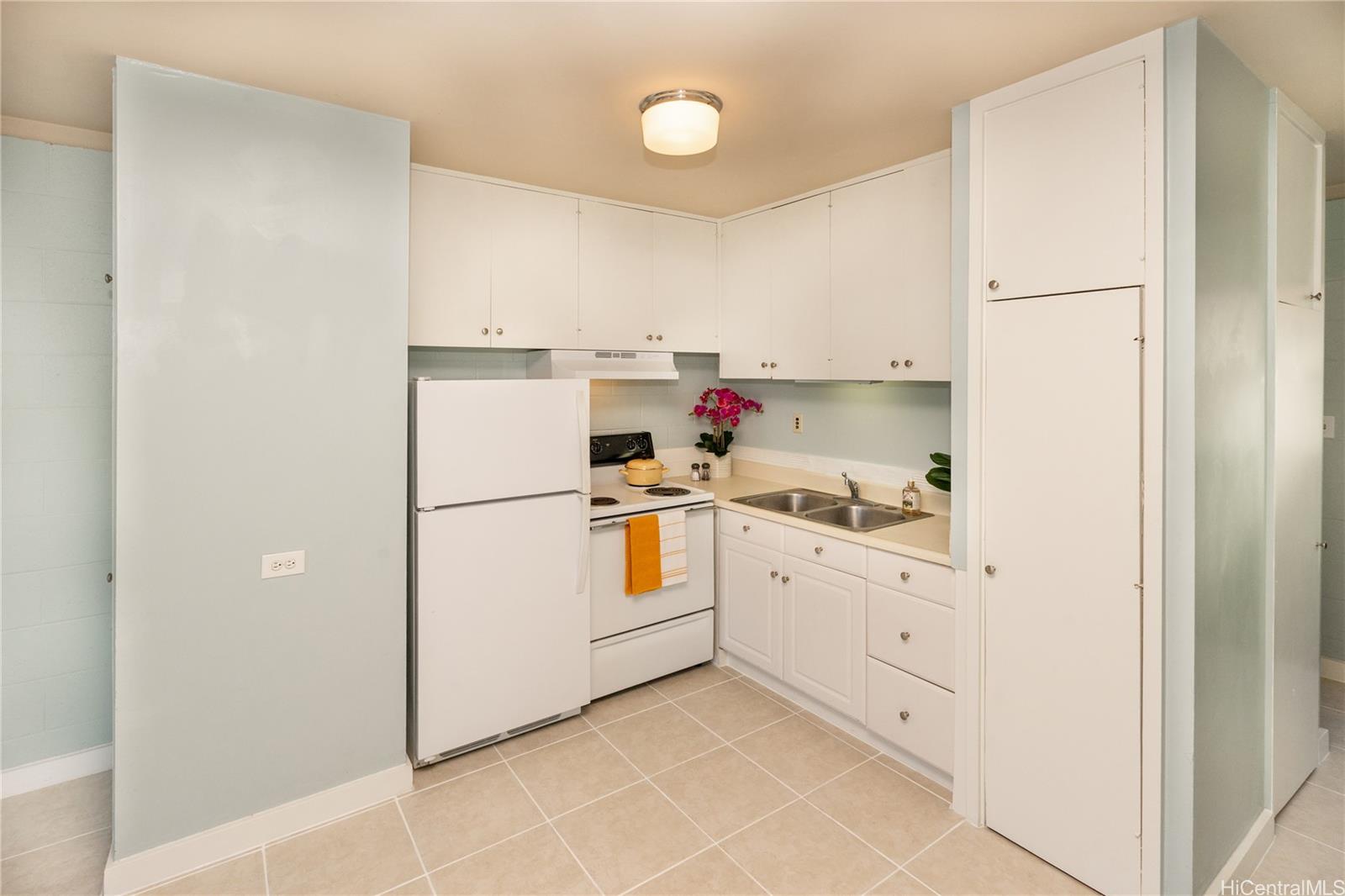 98-135 Lipoa Place, Unit 301 Aiea, HI 96701 - Photo 7 of 17 a kitchen with white cabinets and white appliances