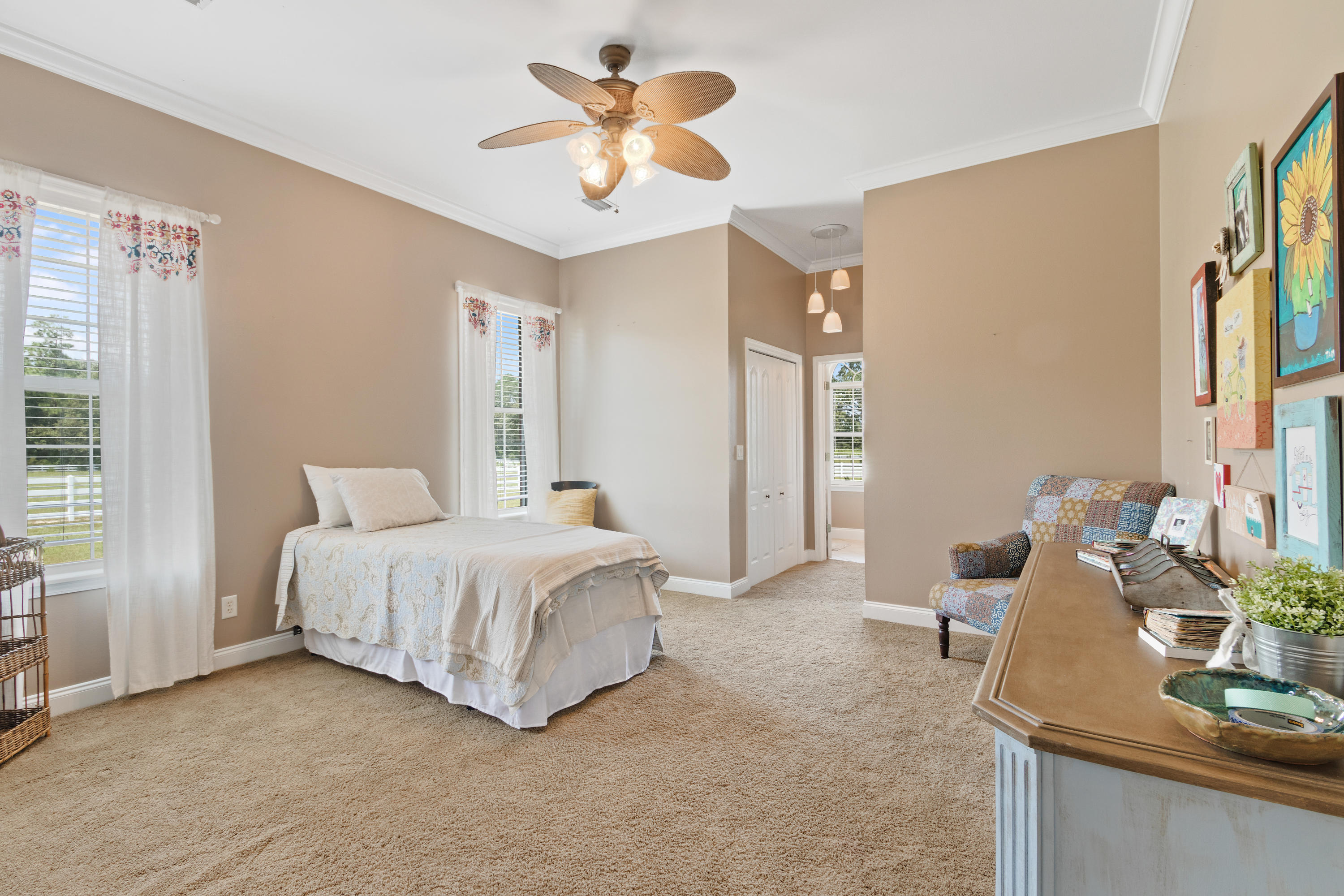 1498 Sky Ranch Lane Baker, FL 32531 - Photo 41 of 86 a spacious bedroom with a bed a chandelier and a mirror
