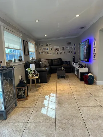 a living room with furniture a window and a flat screen tv