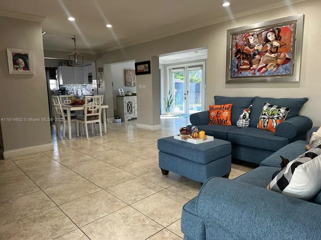 a living room with furniture and a view of kitchen
