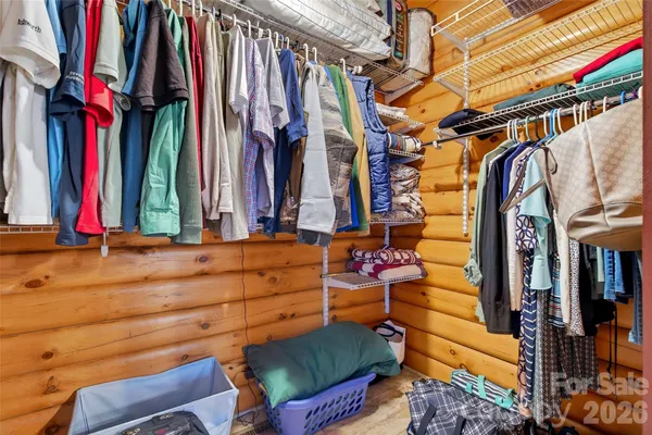 a view of walk in closet with clothes and shoes