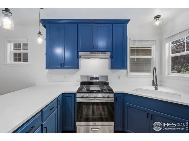a kitchen with granite countertop a stove sink and cabinets