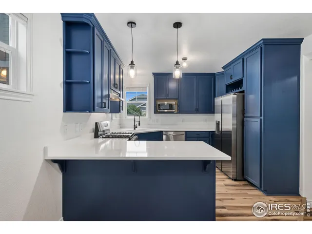 a kitchen with stainless steel appliances granite countertop a sink refrigerator and cabinets