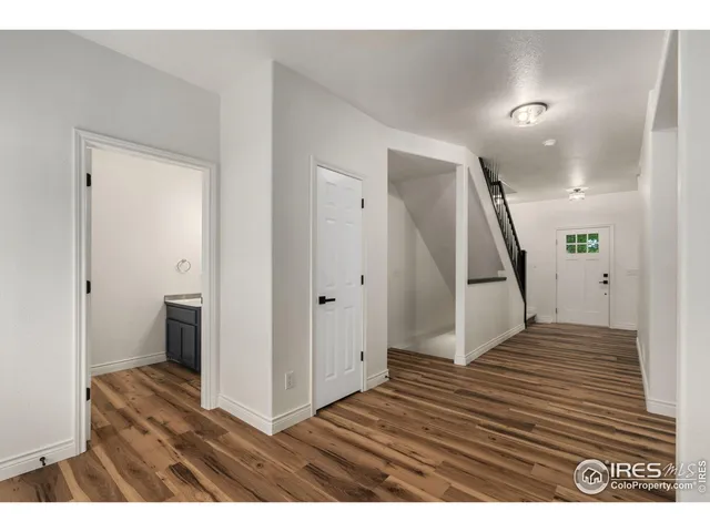 a view of a hallway with wooden floor and staircase