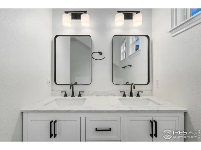 a bathroom with double vanity sinks and a mirror