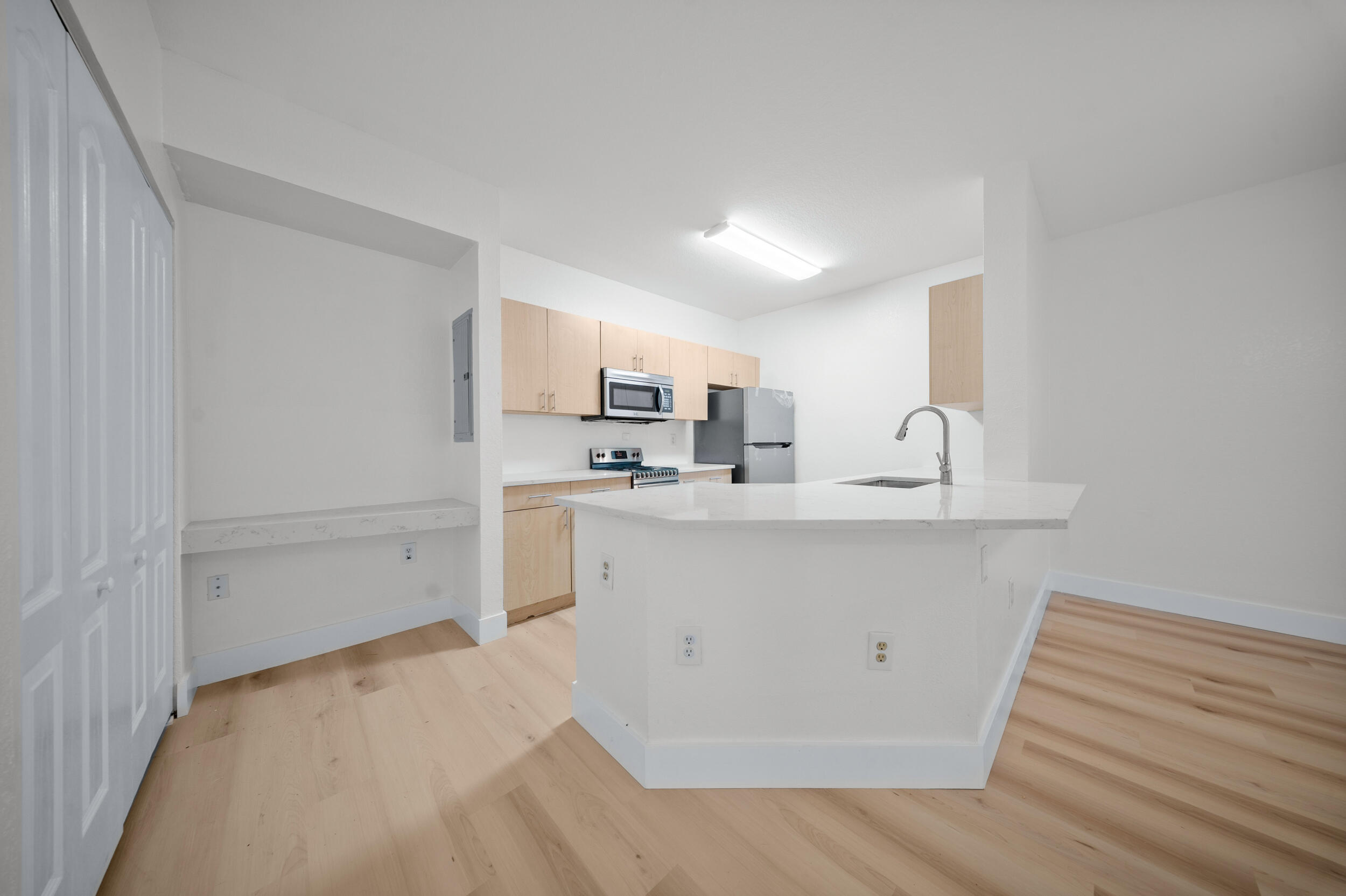 110 Southwest Peacock Boulevard, Unit 6102 Port St. Lucie, FL 34986 - Photo 12 of 40 a view of a kitchen with white cabinets and wooden floor