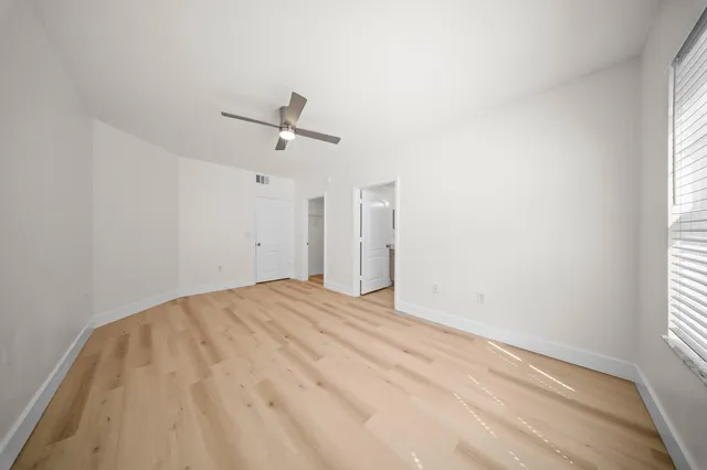 a view of a room with a ceiling fan and a window