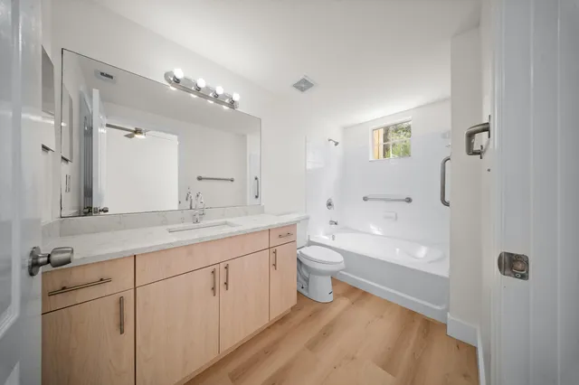 a bathroom with a granite countertop sink mirror and toilet