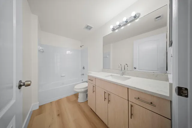 a bathroom with a sink a toilet a mirror and vanity