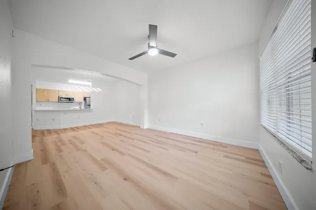 wooden floor in an empty room with a kitchen