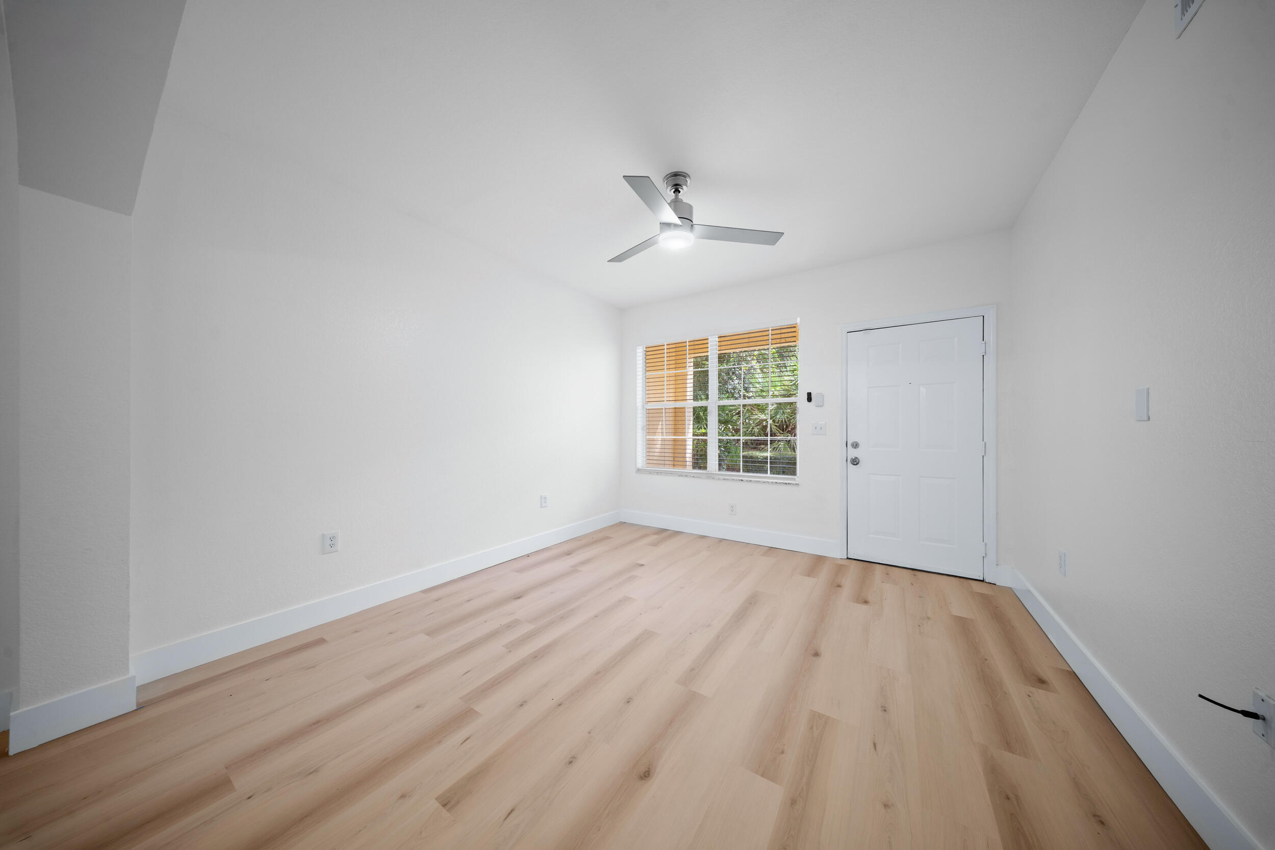 110 Southwest Peacock Boulevard, Unit 6102 Port St. Lucie, FL 34986 - Photo 6 of 40 wooden floor in an empty room with a window