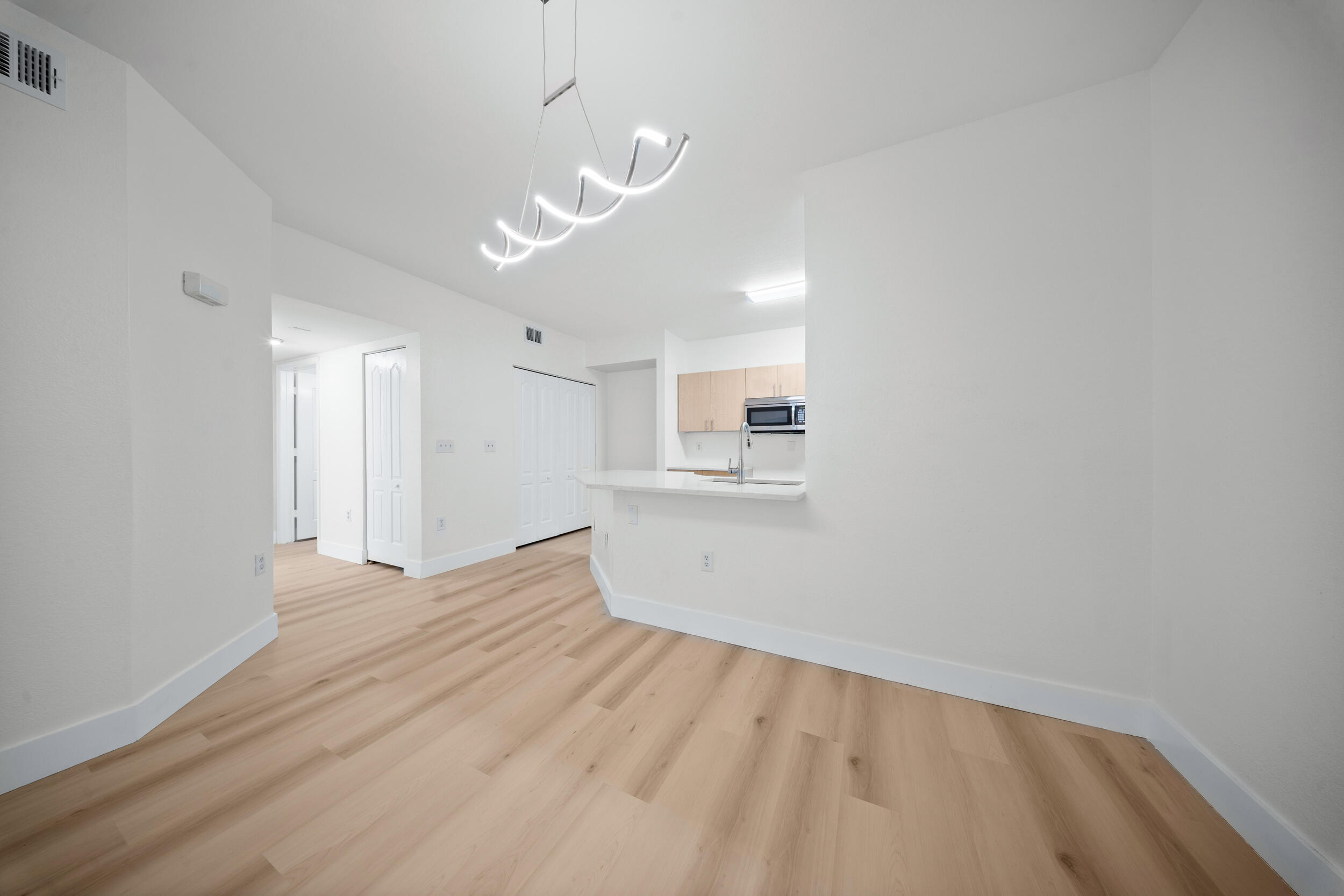 110 Southwest Peacock Boulevard, Unit 6102 Port St. Lucie, FL 34986 - Photo 9 of 40 a view of empty room with wooden floor and windows