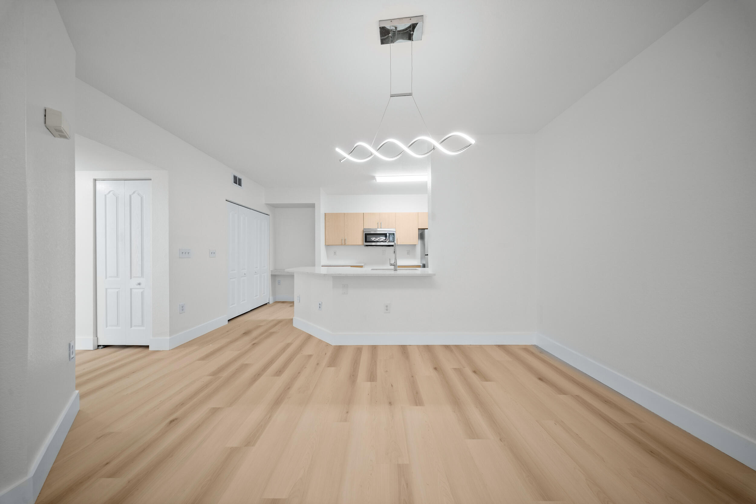 110 Southwest Peacock Boulevard, Unit 6102 Port St. Lucie, FL 34986 - Photo 10 of 40 a view of a room with wooden floor and kitchen view