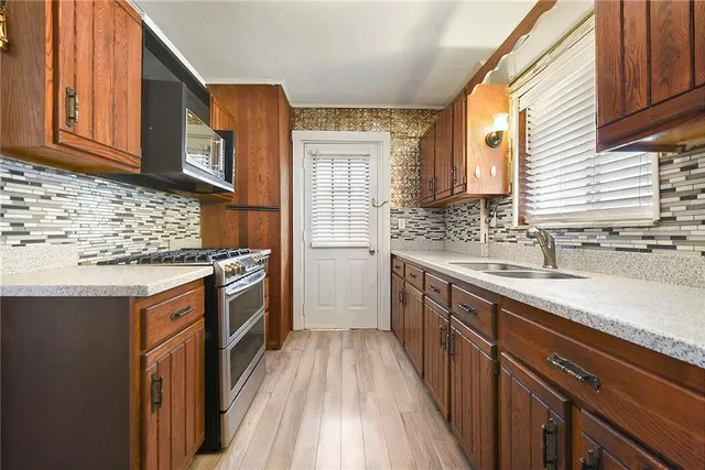 a kitchen with stainless steel appliances granite countertop a sink stove and cabinets