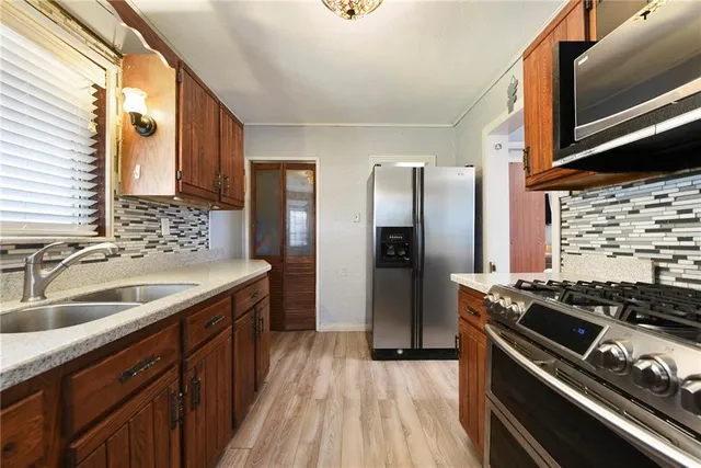 a kitchen with stainless steel appliances granite countertop a sink stove and refrigerator