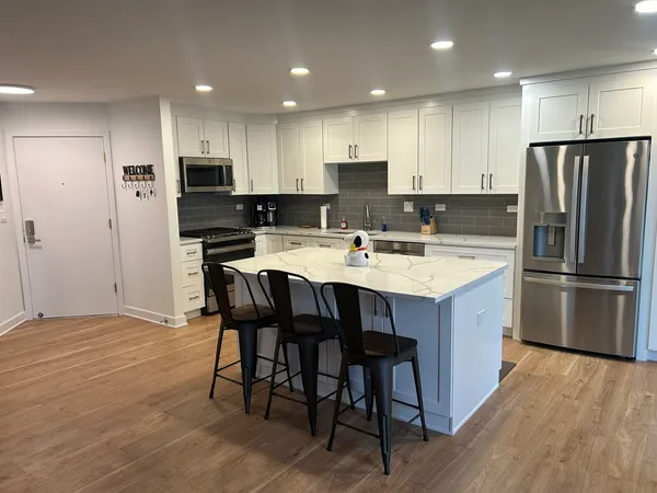 a kitchen with stainless steel appliances a refrigerator a stove a sink and a oven