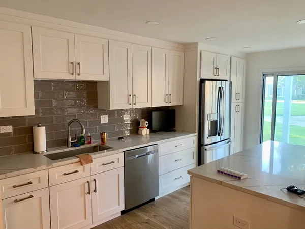 a kitchen with stainless steel appliances granite countertop a refrigerator sink and cabinets