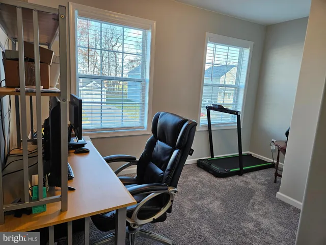 a view of a workspace with furniture and a window