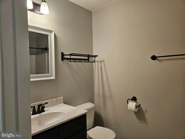 a bathroom with a sink mirror and toilet