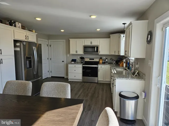 a kitchen with stainless steel appliances granite countertop a refrigerator a stove top oven a sink and dishwasher